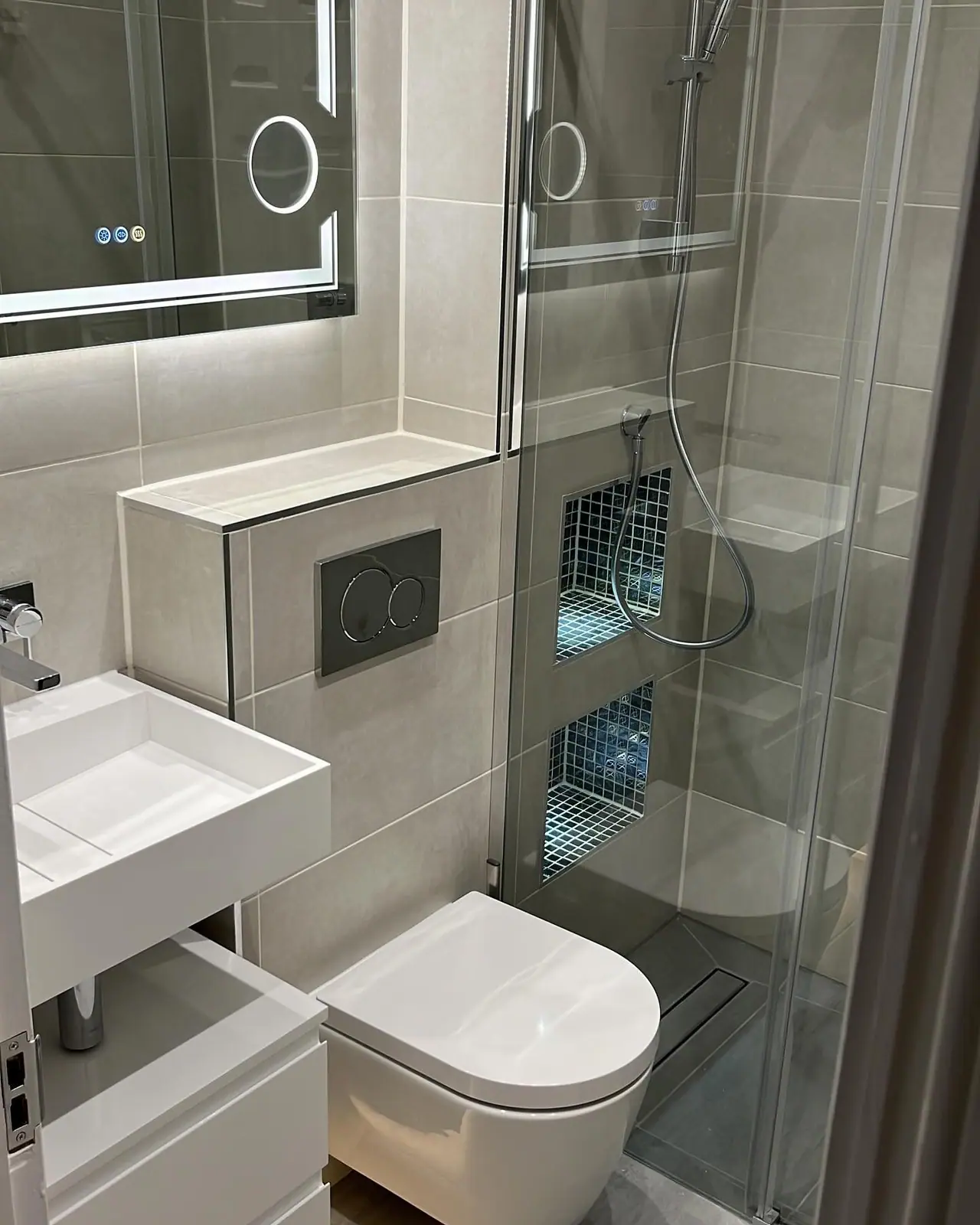 The walk-in shower, concealed cistern boxing and mosaic niches