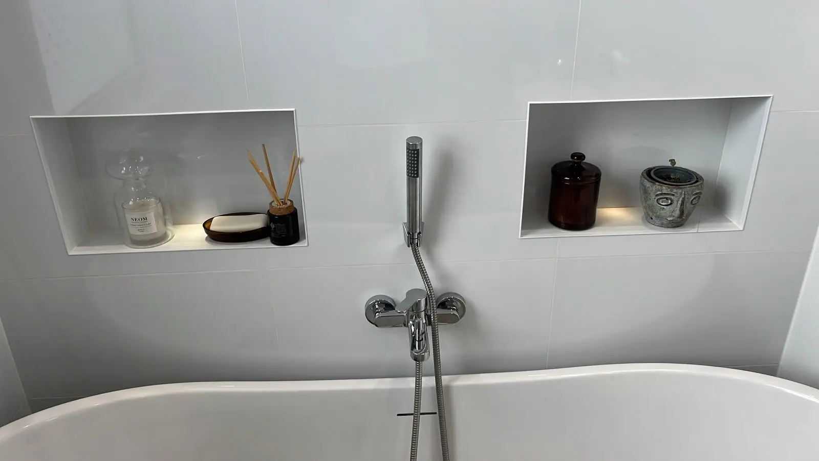 The two lit recessed niches above the bath