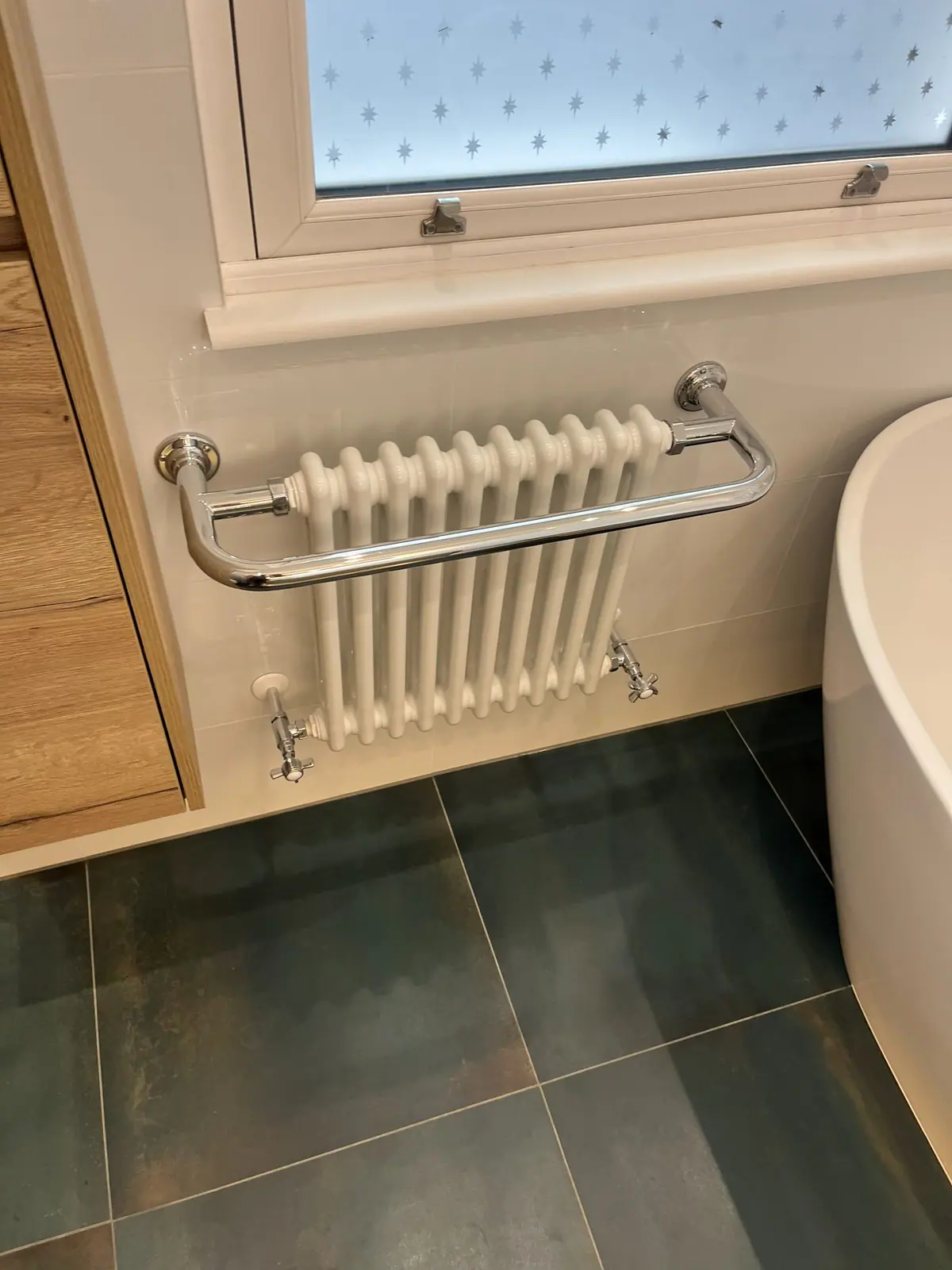The column radiator and towel rail under the window