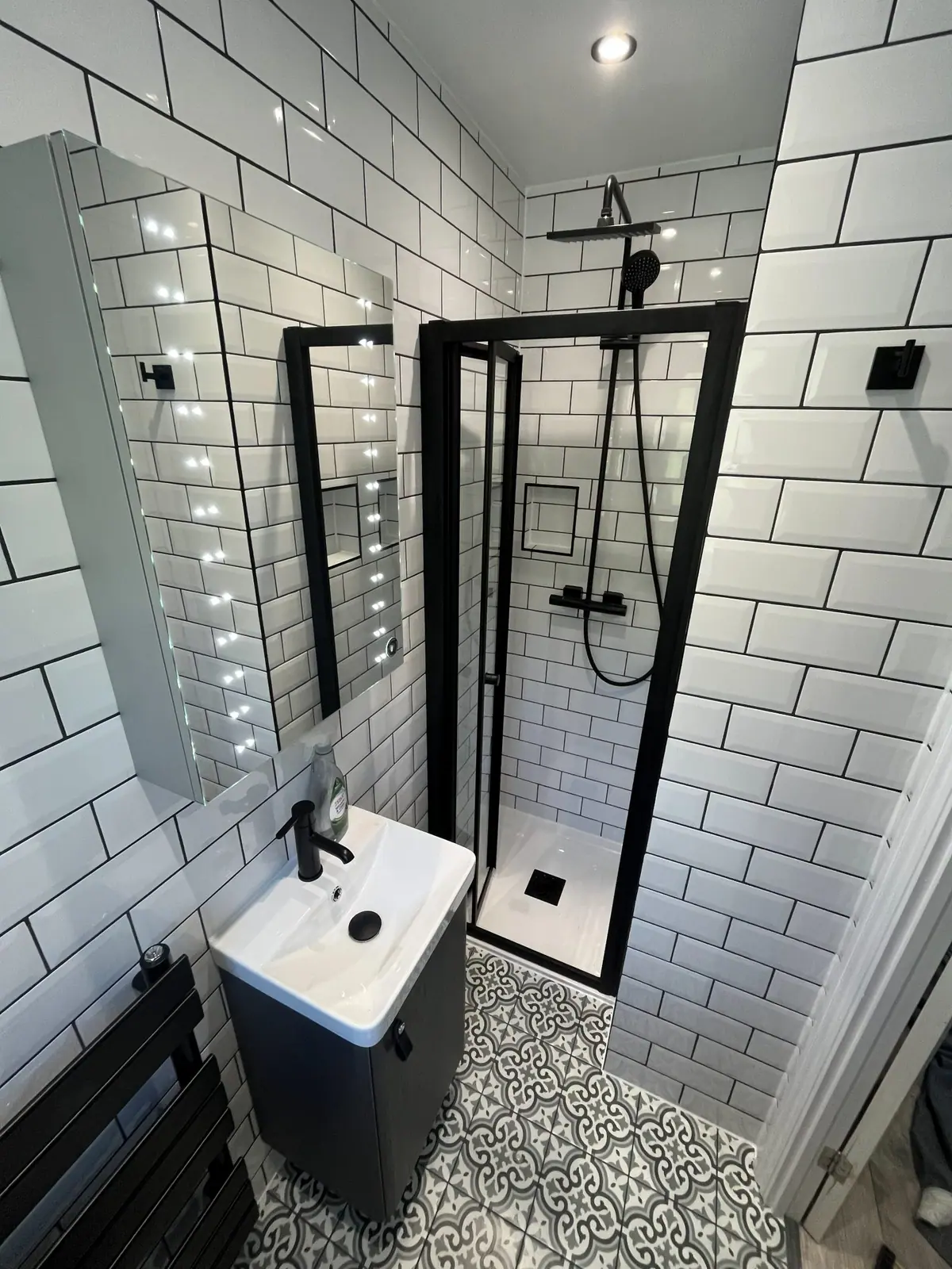 The black-framed shower enclosure and vanity basin