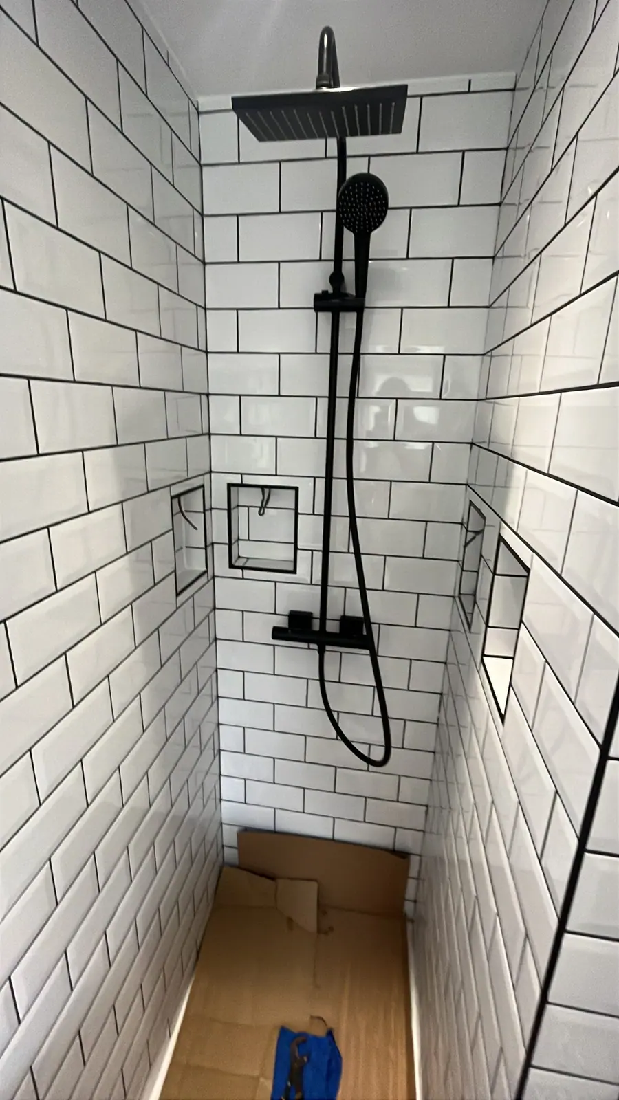Inside the shower, with the black rainfall head and recessed niches