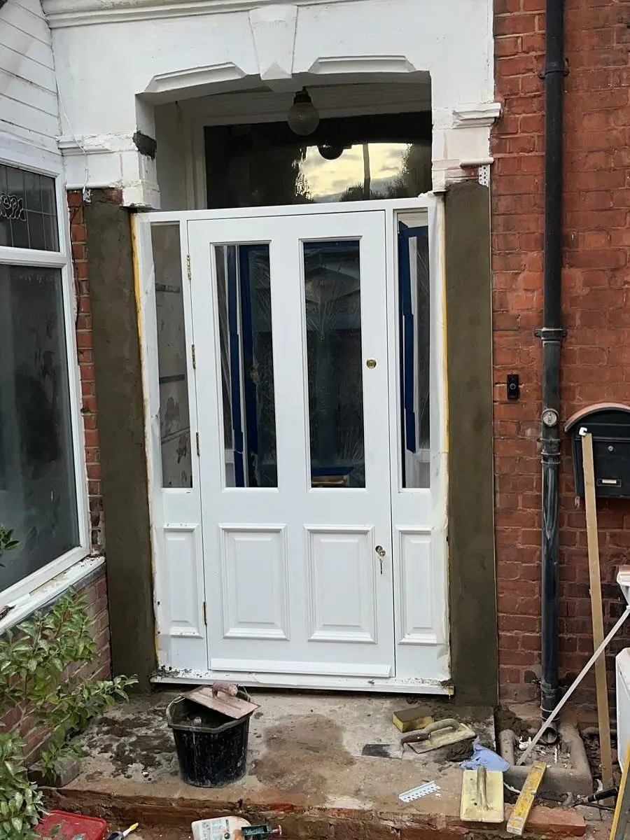 Before: the old white front door in its frame, with the reveals opened up