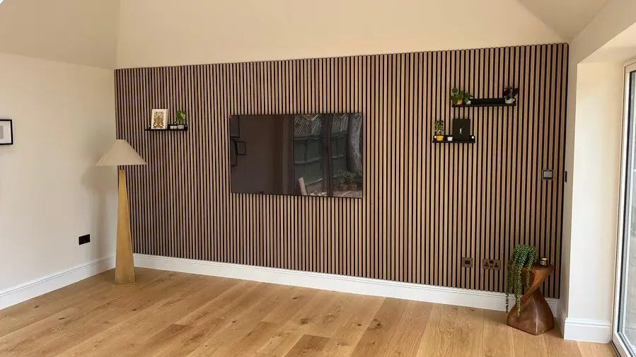 The finished room inside, with an oak floor and a slatted timber feature wall