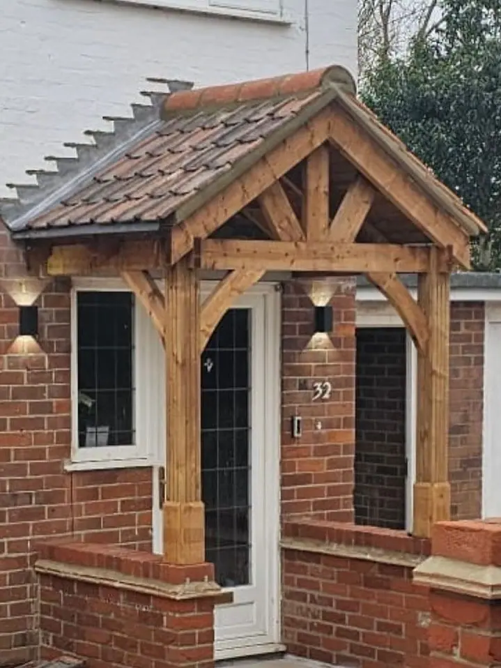 The finished oak-framed porch with a clay-tiled roof and wall lights