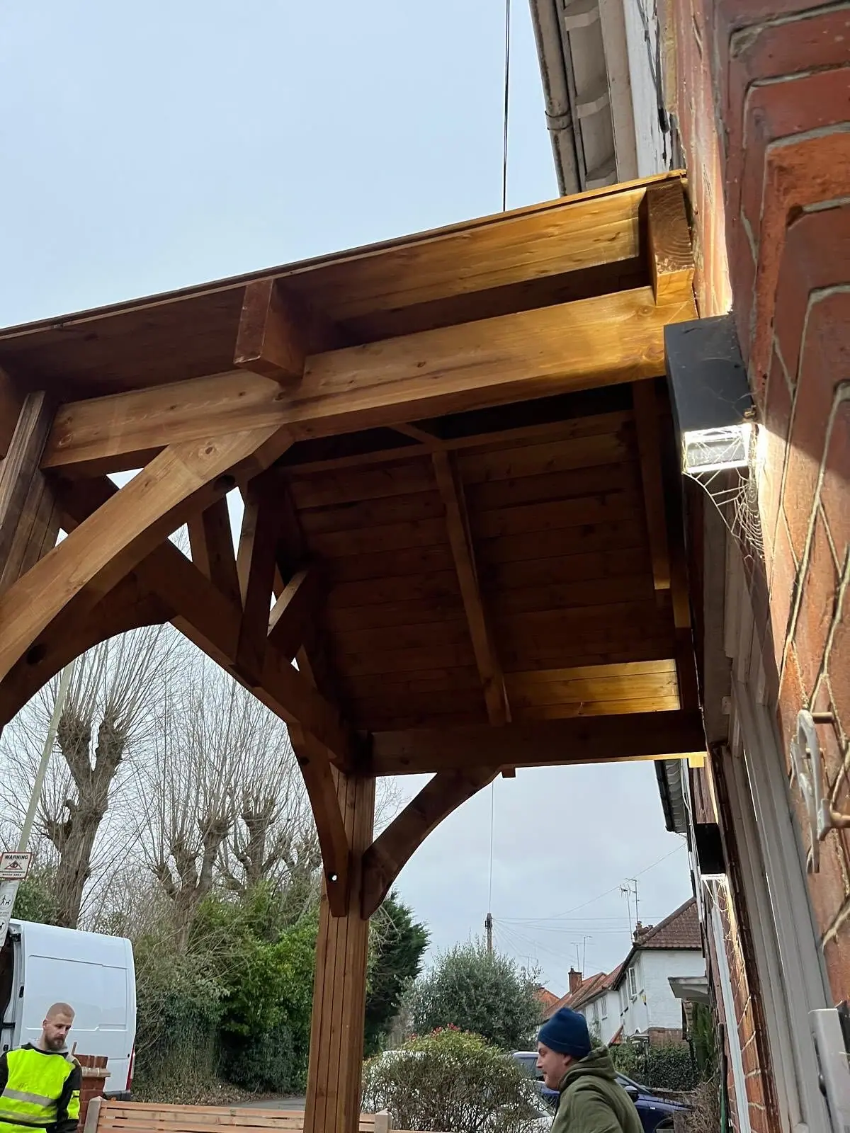The oak porch frame from below, showing the curved braces and rafters