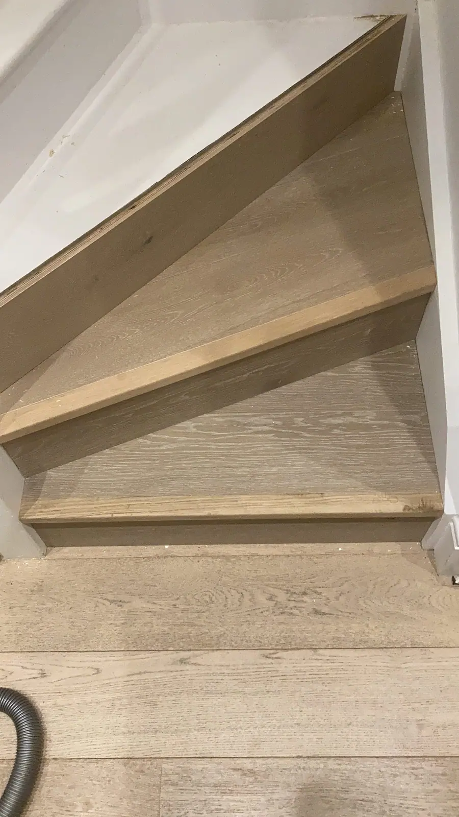 The bottom winder steps of the same staircase meeting the new floor