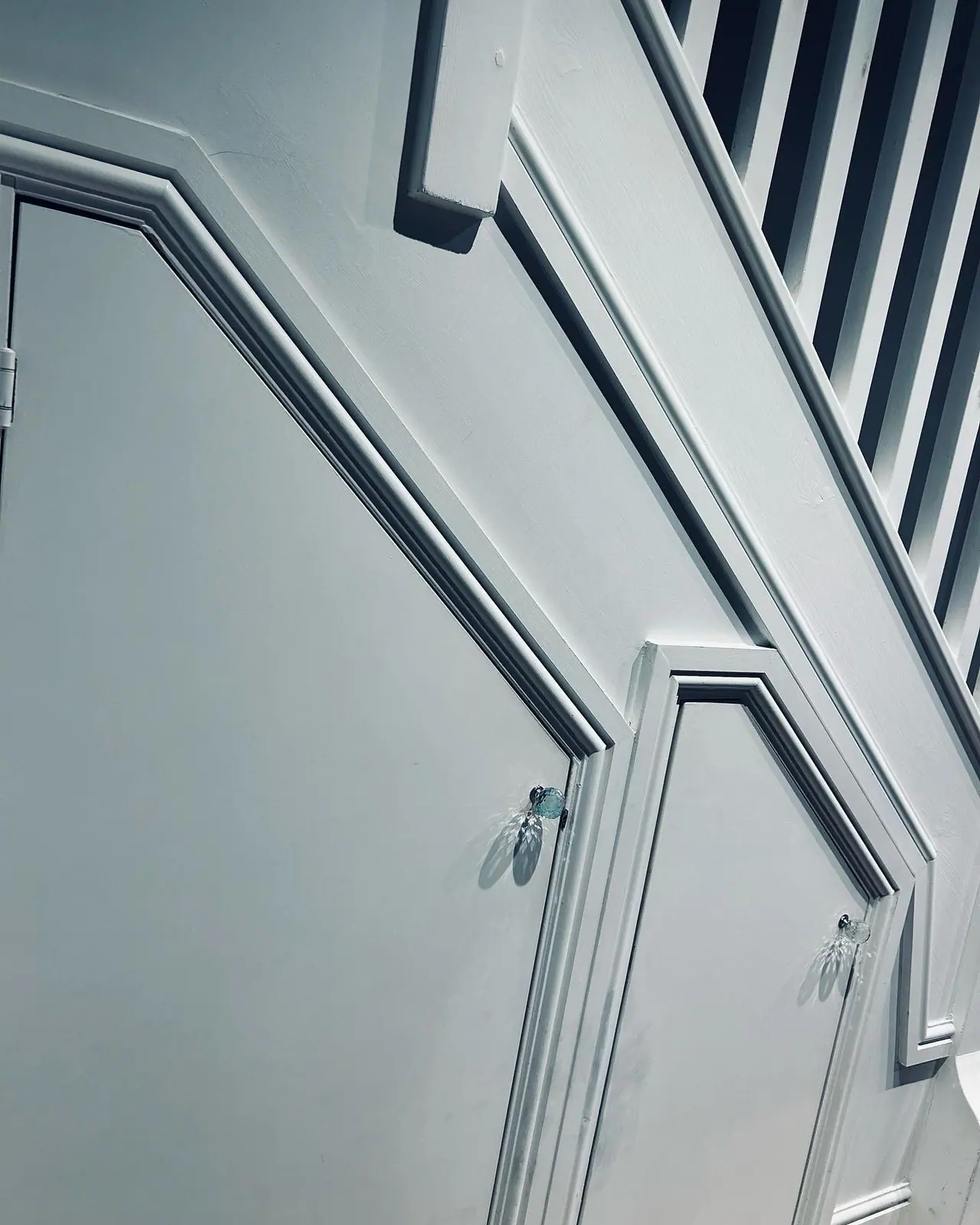 Panelled doors under a staircase, finished to match the stair string