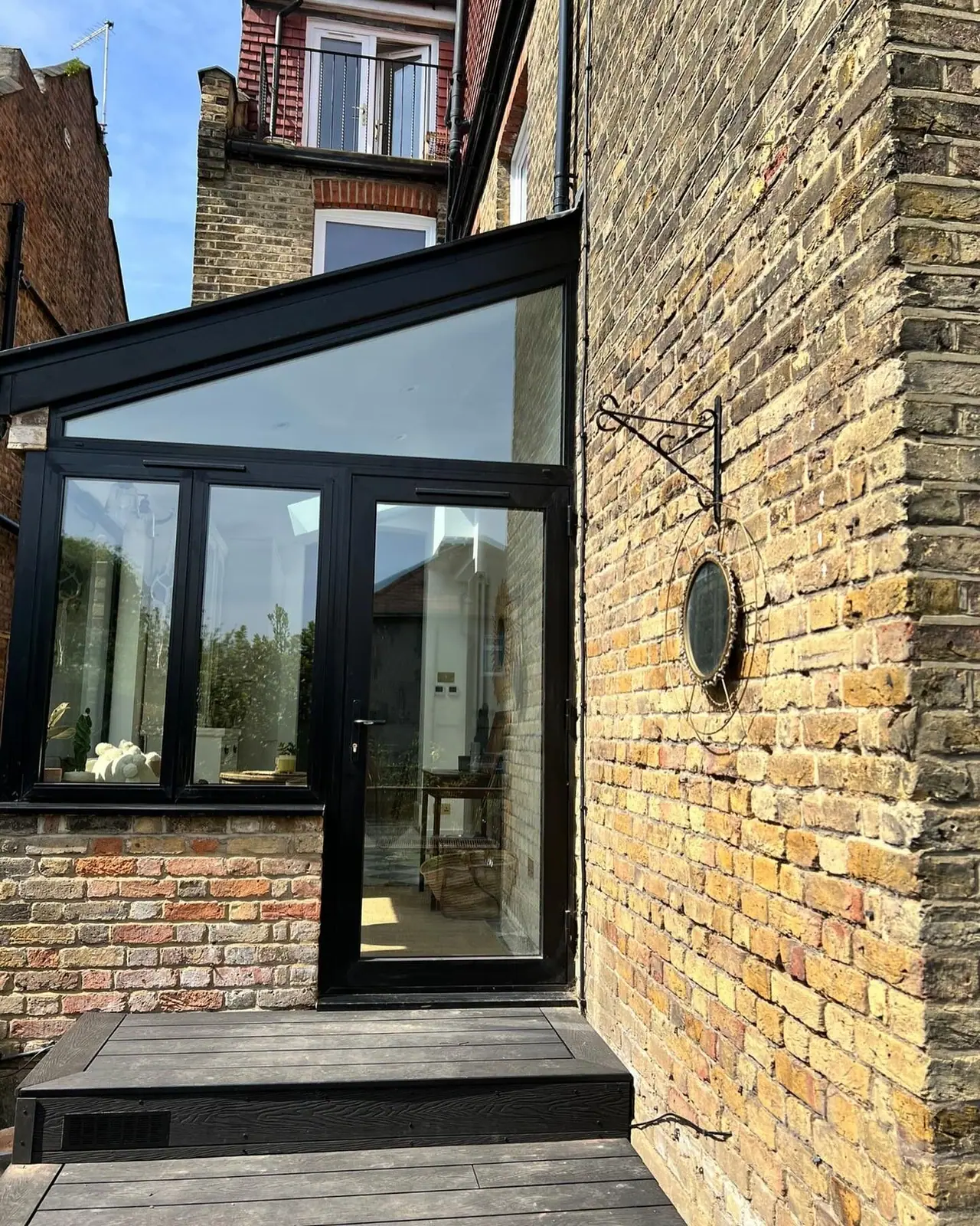 The black-framed glazing and door at the end of the side return
