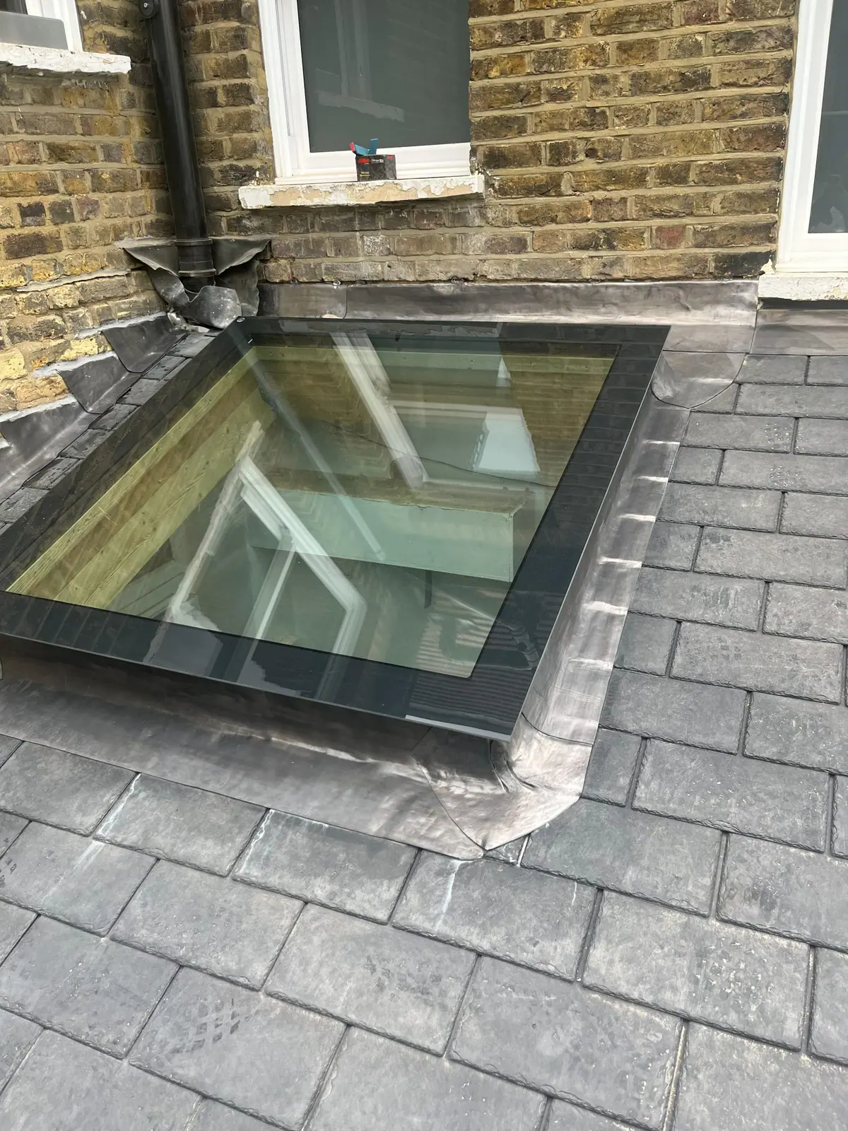 Close view of a roof light set into the slate with lead flashing