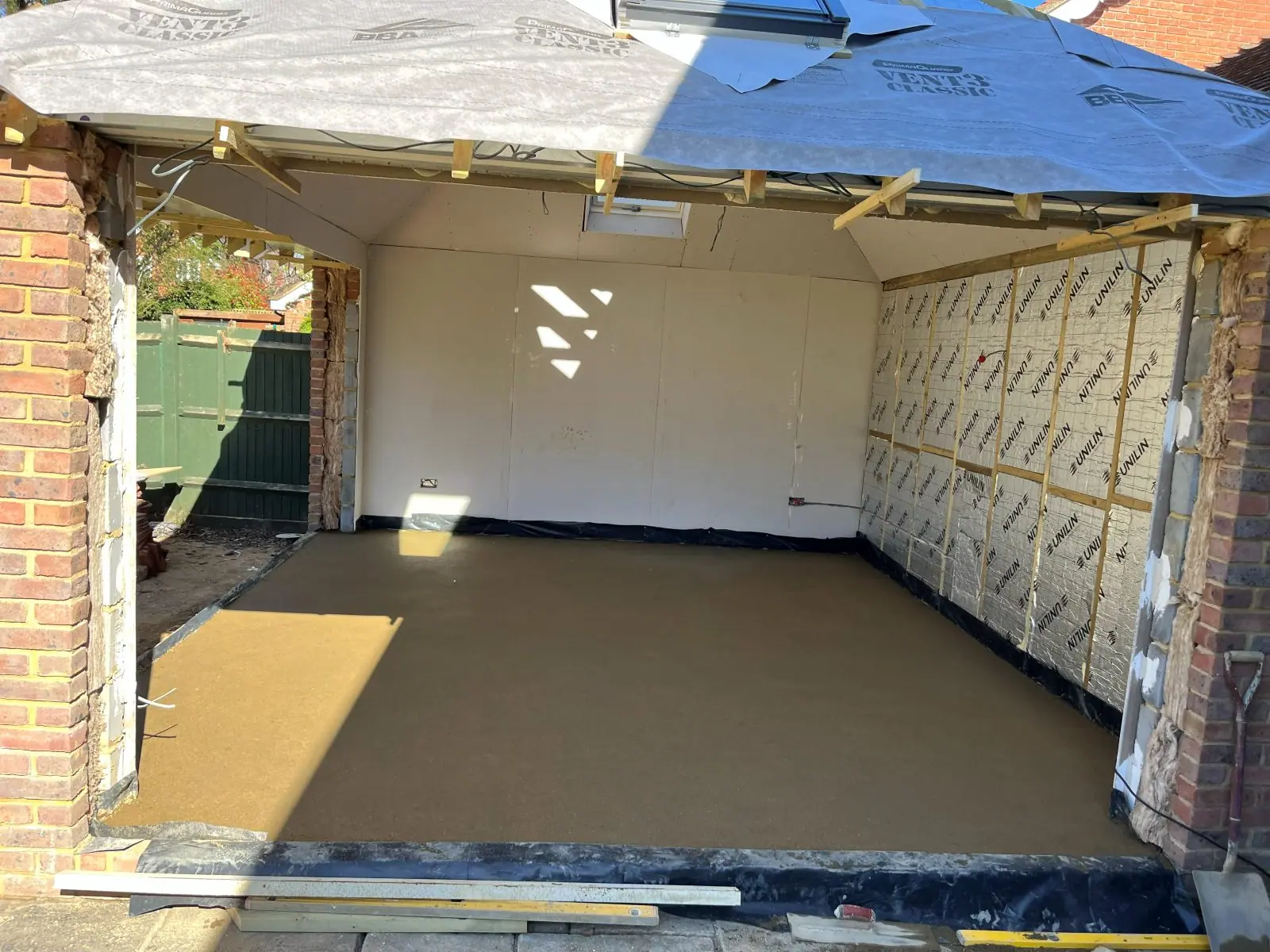 Inside the shell: insulated walls, plasterboard going up and a level floor screed