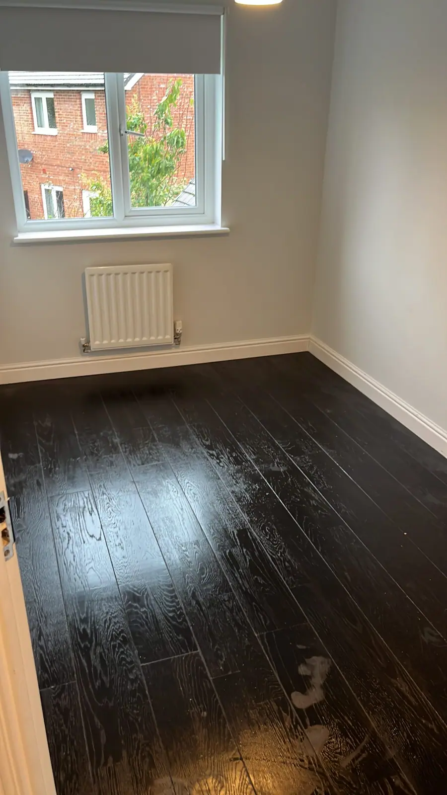 A dark timber floor covered in dust and marks before it was refinished