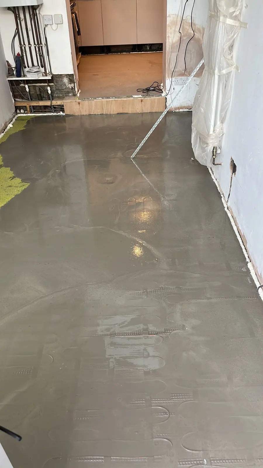 A fresh levelling screed poured over the heating mats