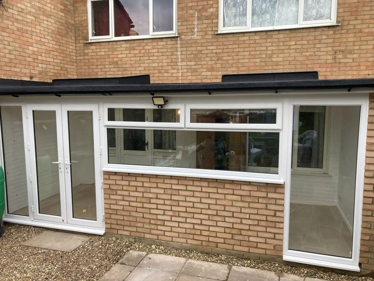 The same elevation rebuilt in brick with new doors and windows under a flat roof