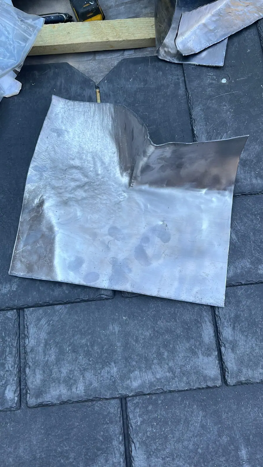 A piece of lead cut and bossed to shape on a slate roof