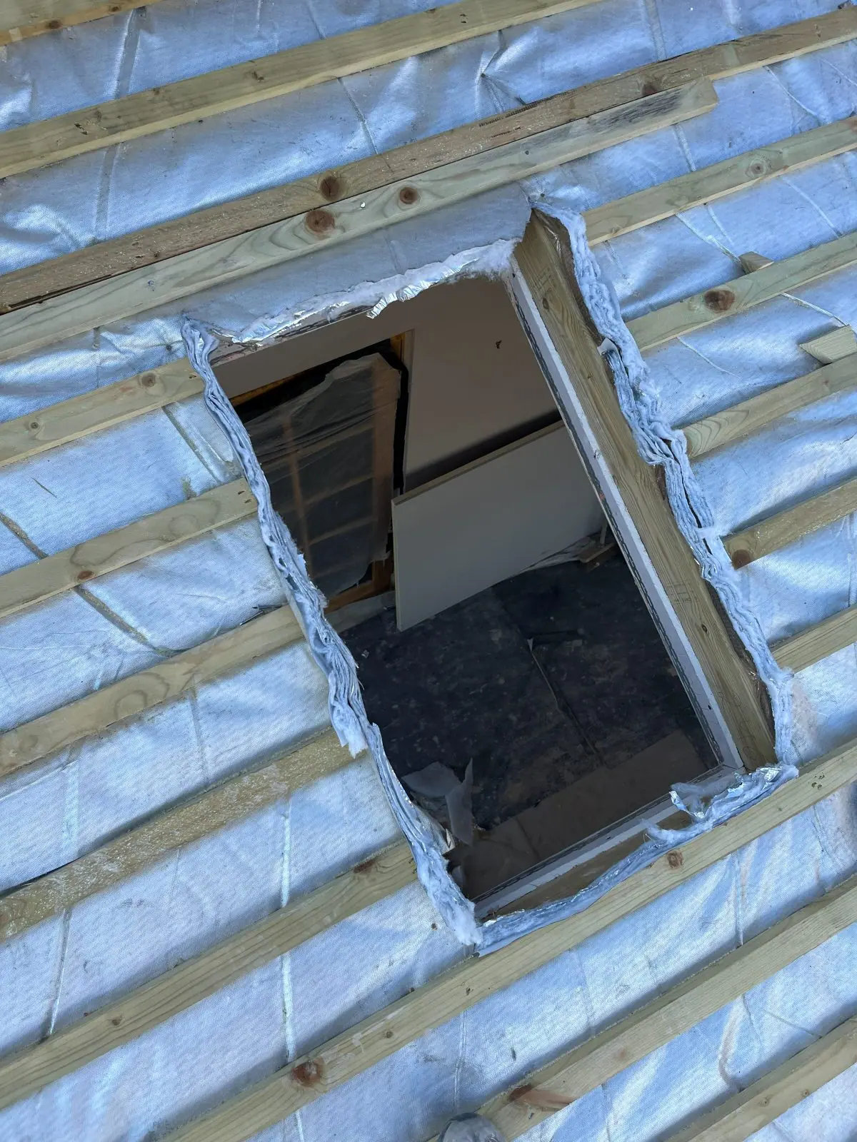 An opening for a roof window formed in new battens and breathable membrane