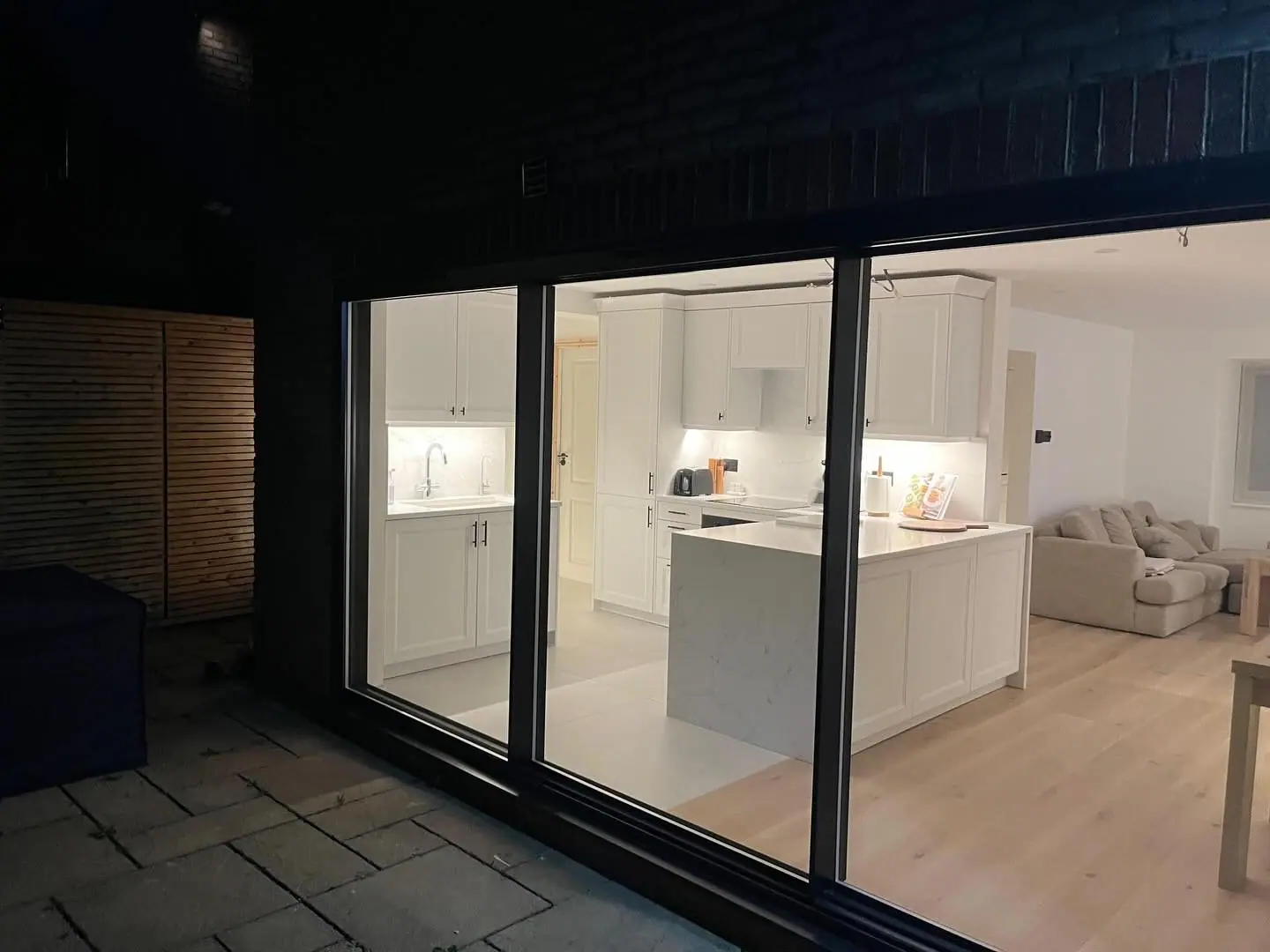 The kitchen at night seen from the garden