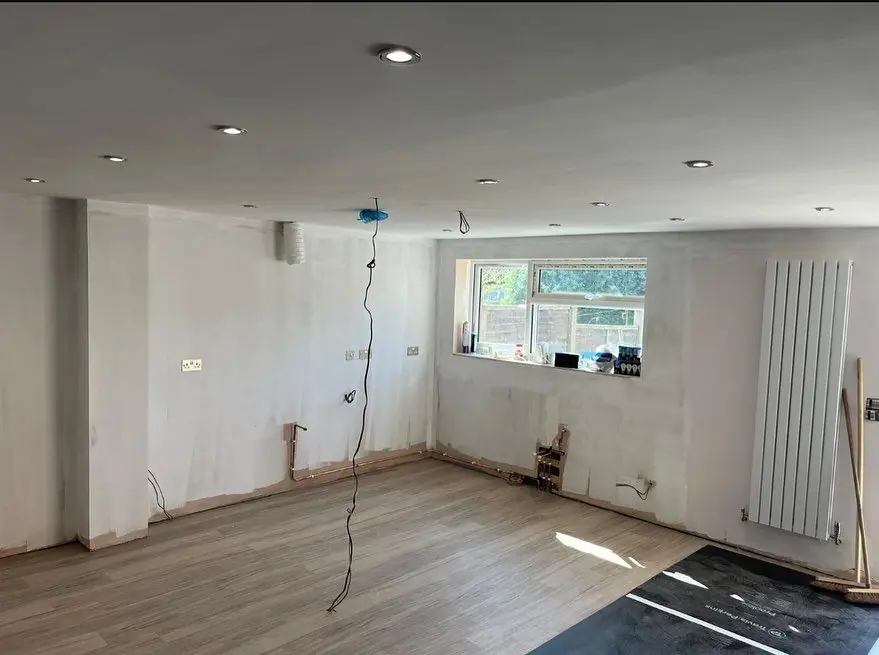 The room stripped out, with bare walls, capped services and a new radiator