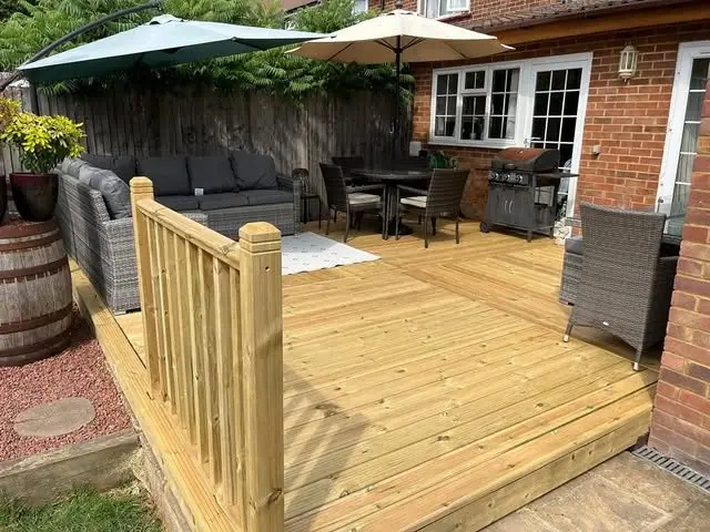 A raised timber deck with a handrail and step, furnished and in use