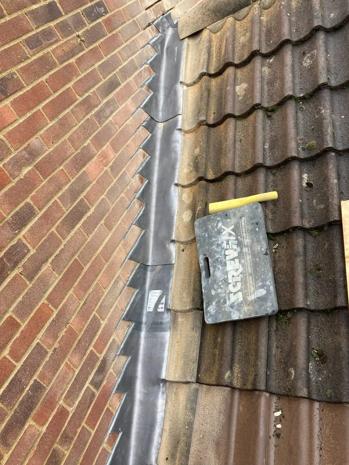 The same run of stepped flashing seen further down the slope towards the eaves