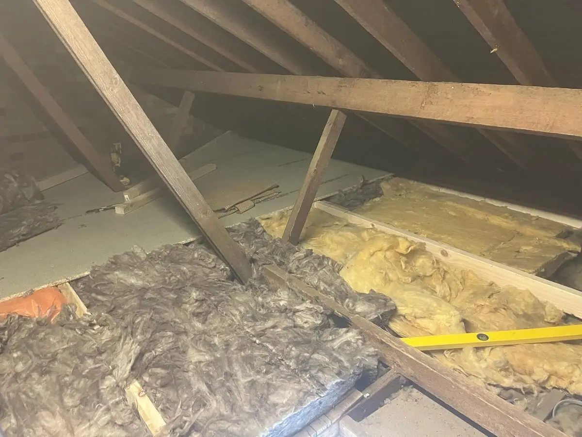 The loft before, with old insulation loose between the joists
