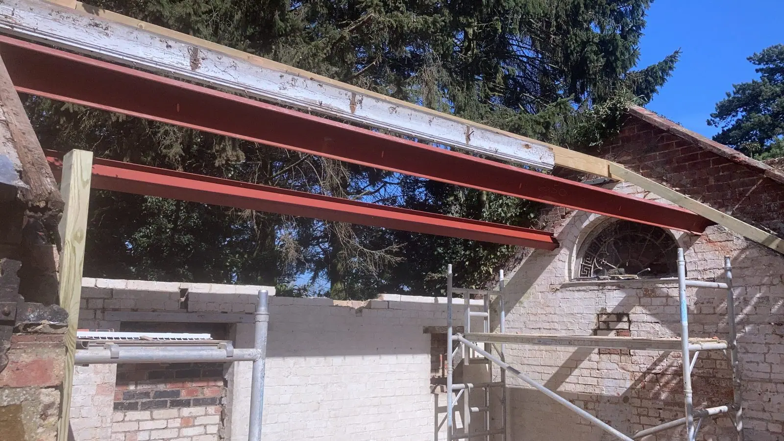 New steel beams bearing on the walls of the outbuilding, ready for the rafters