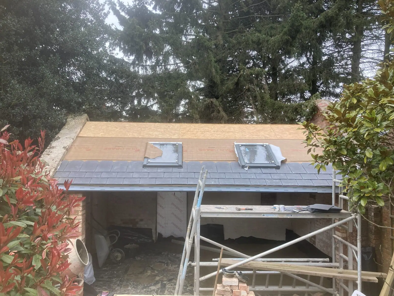 Slate going on over the lower half of the roof, with the roof windows fitted above