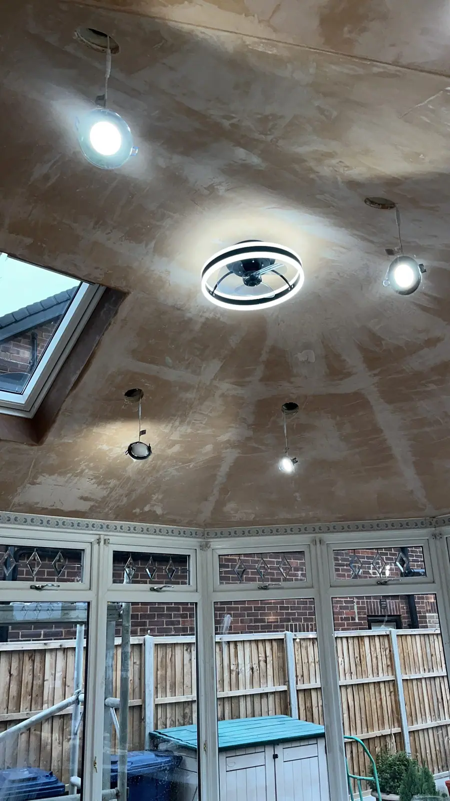 Inside a conservatory under its new solid roof, with a plastered ceiling, spotlights and a roof window