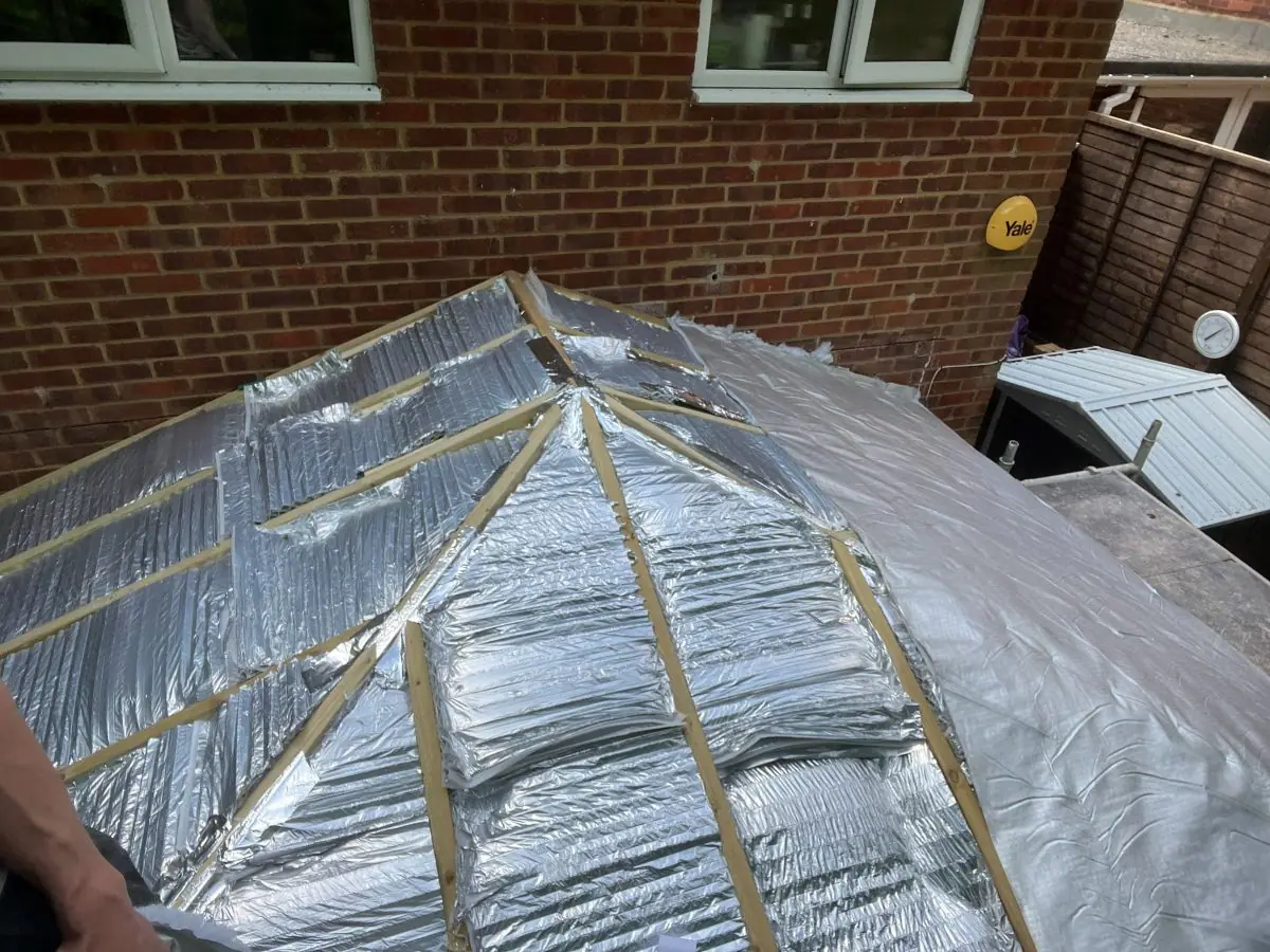 Foil-faced insulation fitted between the new rafters of a conservatory roof